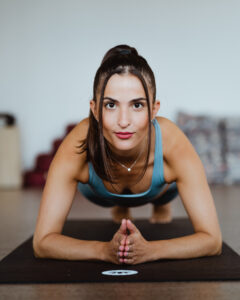 woman in yoga pose faces the camera