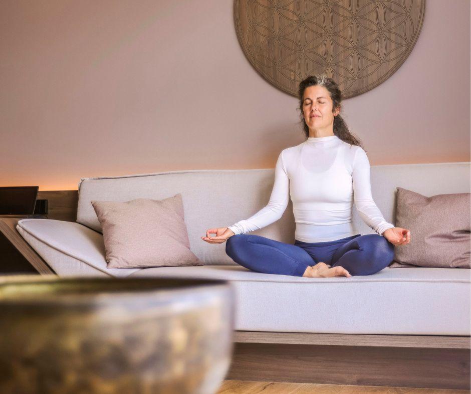 Woman doing breathwork in a yoga pose at the SCHWARZWALD PANORAMA Hotel