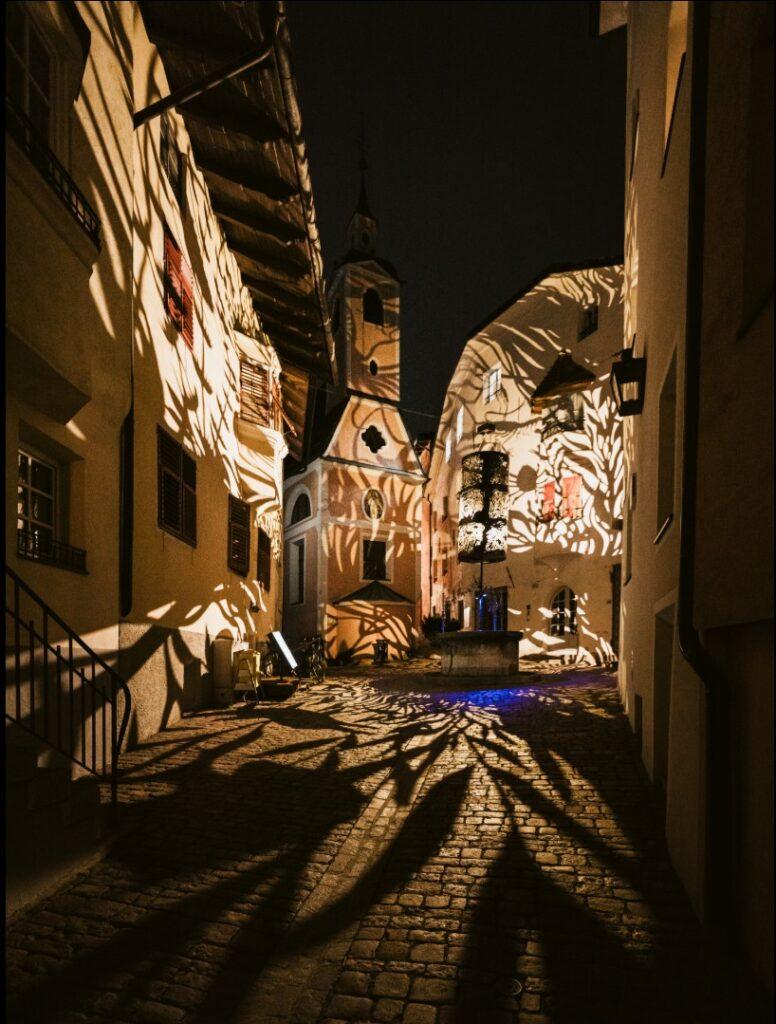 The historic center of Brixen bathed in patterns of light during the Brixen Water Light Festival