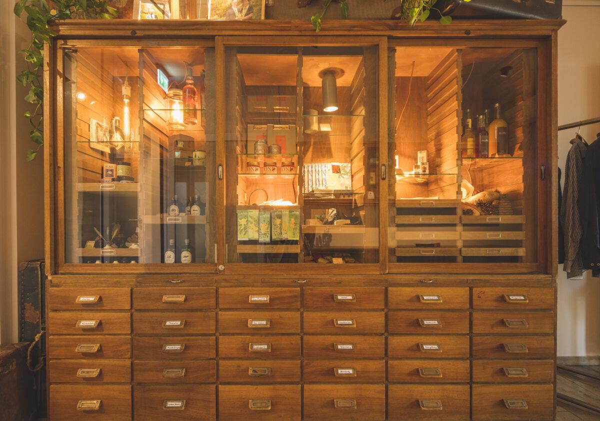 Custom furniture in sustainable hotels—old pharmacy cabinet becomes a tiny shop