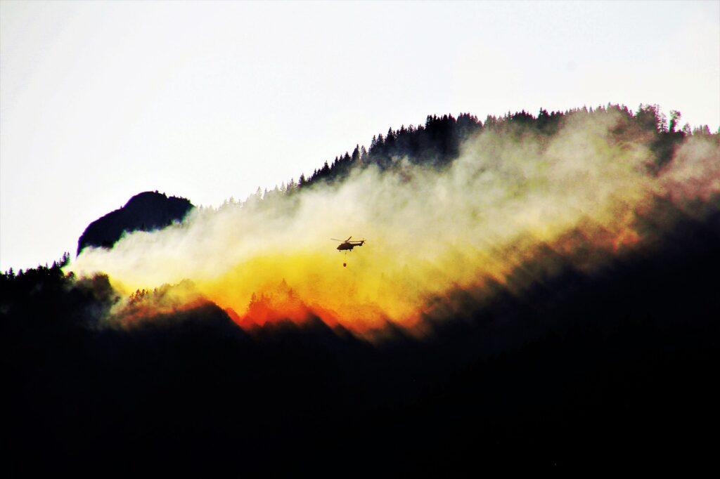 Waldbrand mit einem Helikopter vor der Rauchwolke