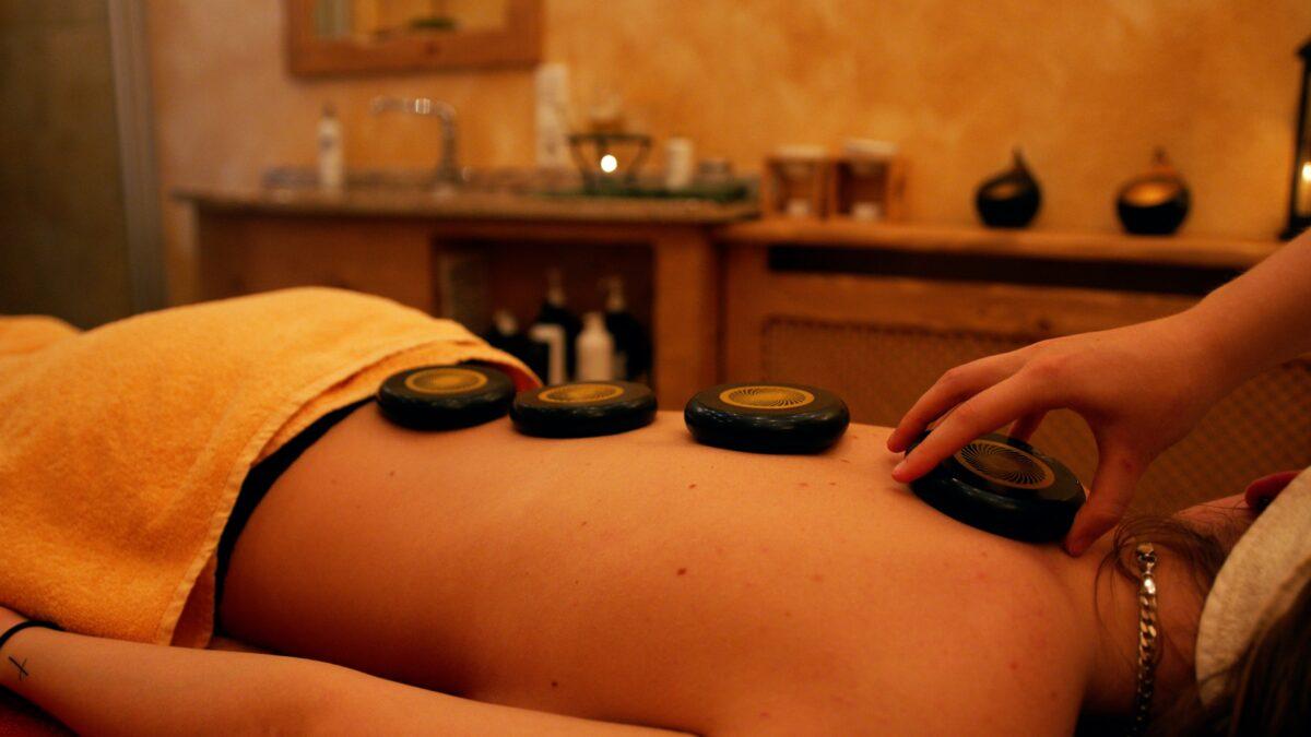 Stress-relieving massage with stones on a woman's back.