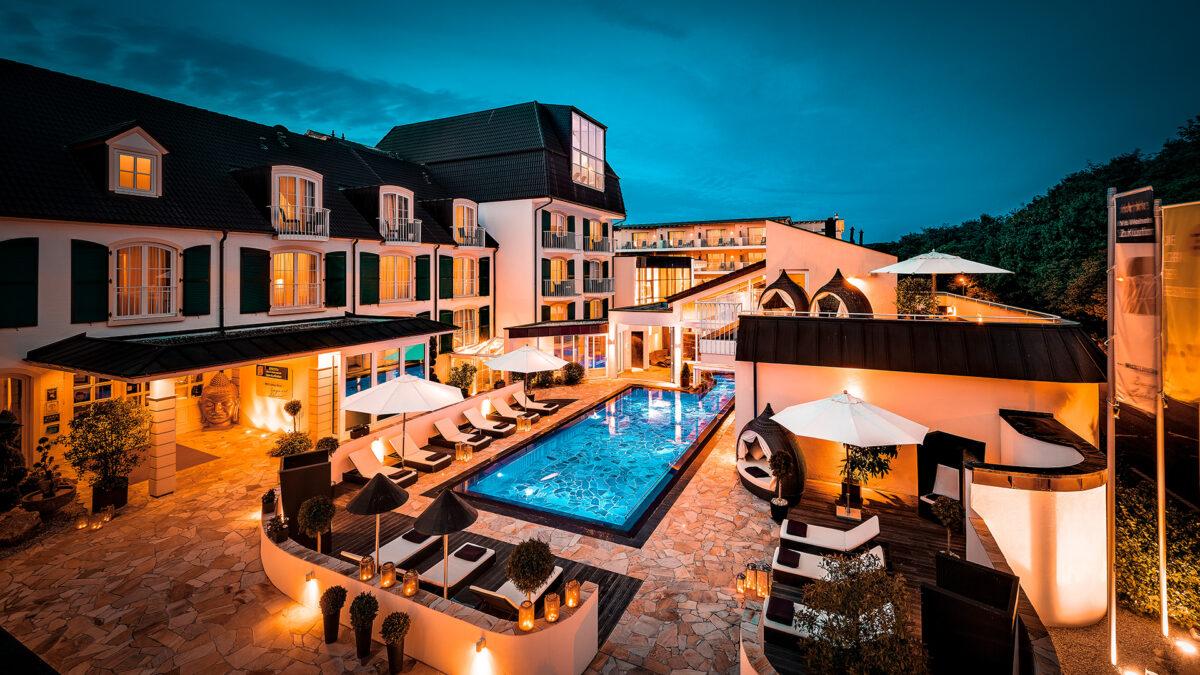 Exterior shot of the Lifestyle Resort Zum Kurfürsten in the dark with illuminated pool
