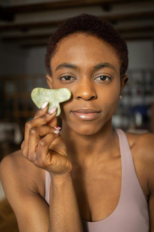 Woman presenting the Gua Sha massage stone