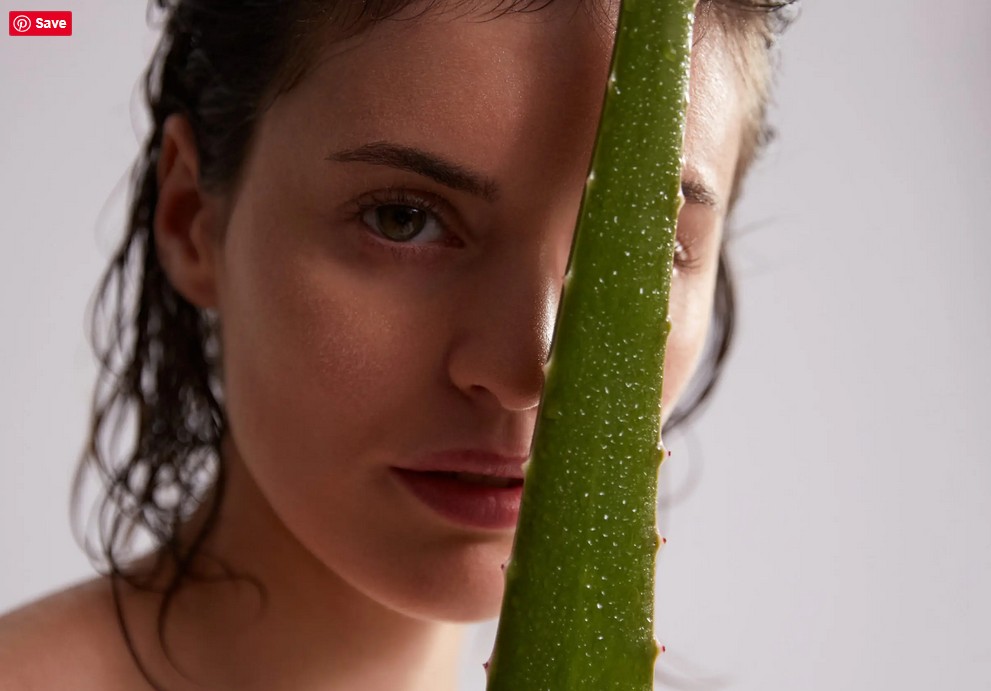 Woman with aloe vera leaf - Pharmos Natur uses fresh aloe vera plant juice instead of water in cosmetics.