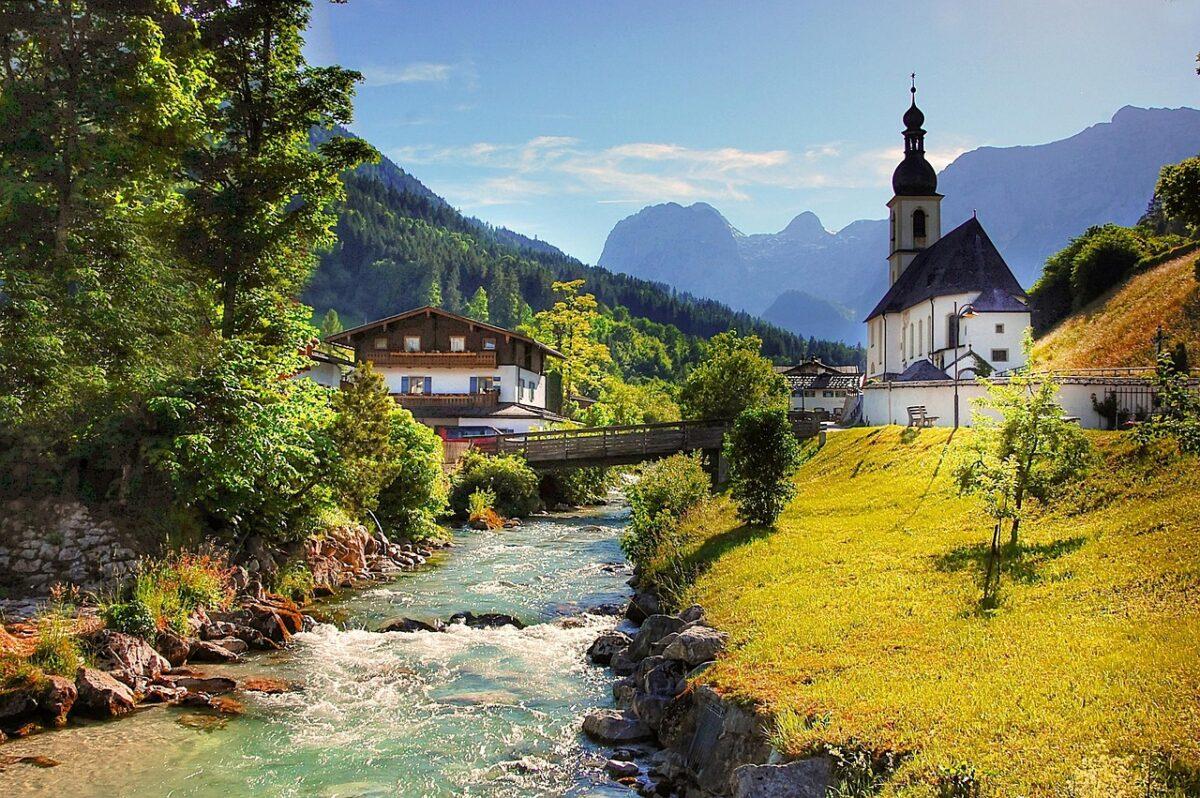 Ramsau in the Berchtesgaden region, featuring a river, a chapel, a farmhouse, and mountain views