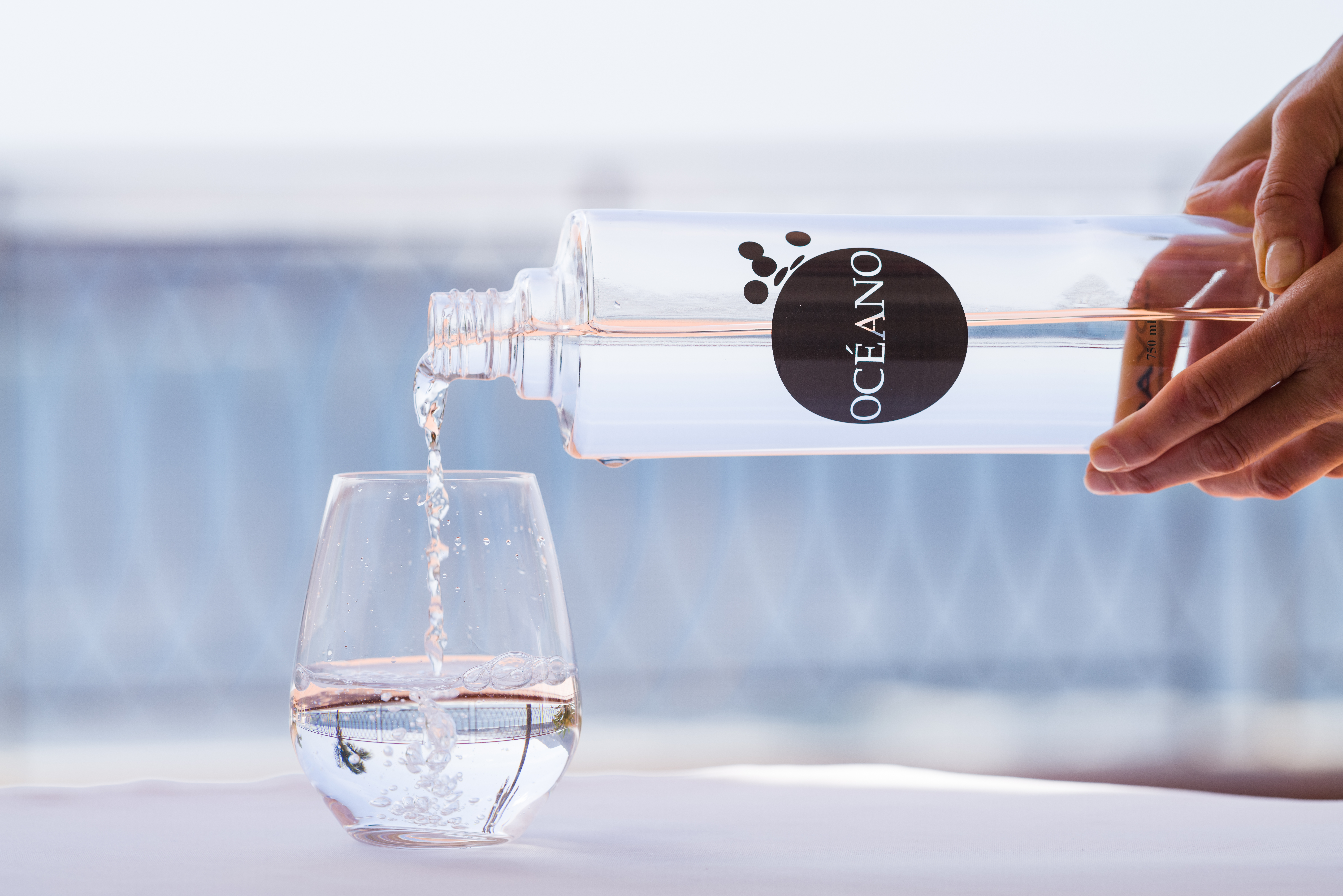 Water is poured from a glass bottle into a water glass.