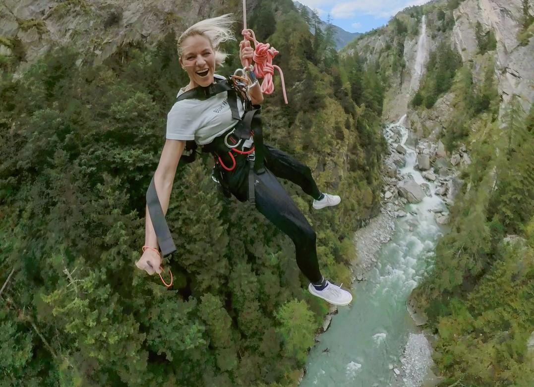 Frau hängt am Bunjee-Seil über der Schlucht