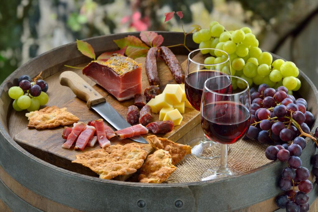 At the Törggelen in South Tyrol with the classic specialties on a wine barrel in addition regional red wine