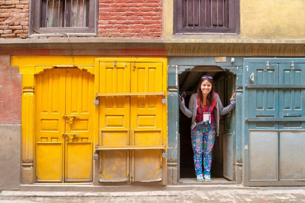 Kathmandu in Nepal lässt sich nachhaltig entdecken. Eine Frau steht in der Tür eines nepalesischen Gebäudes.