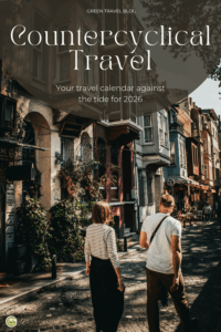 Two people walk down a narrow street lined with old buildings, enlivened by plants and lanterns.