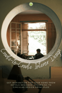 A view through a round window of two people sitting at a table in front of open shutters
