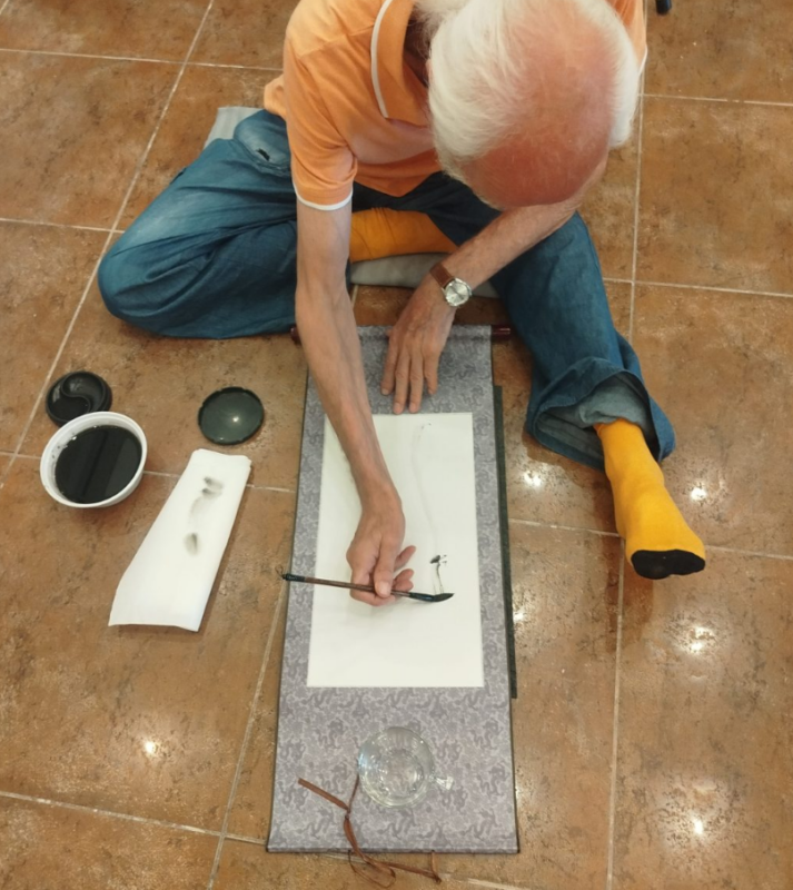 Ein Mann sitzt auf dem Boden und praktiziert japanische Zen Art in einem Workshop im Hotel Korinjak