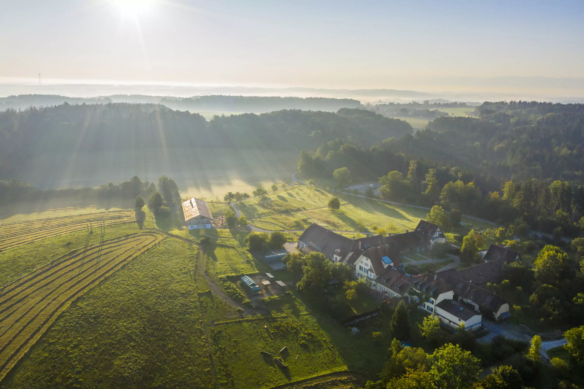 Aerial view of Gut Sonnenhausen. The sustainable hotel is surrounded by fields, nature, and forest.